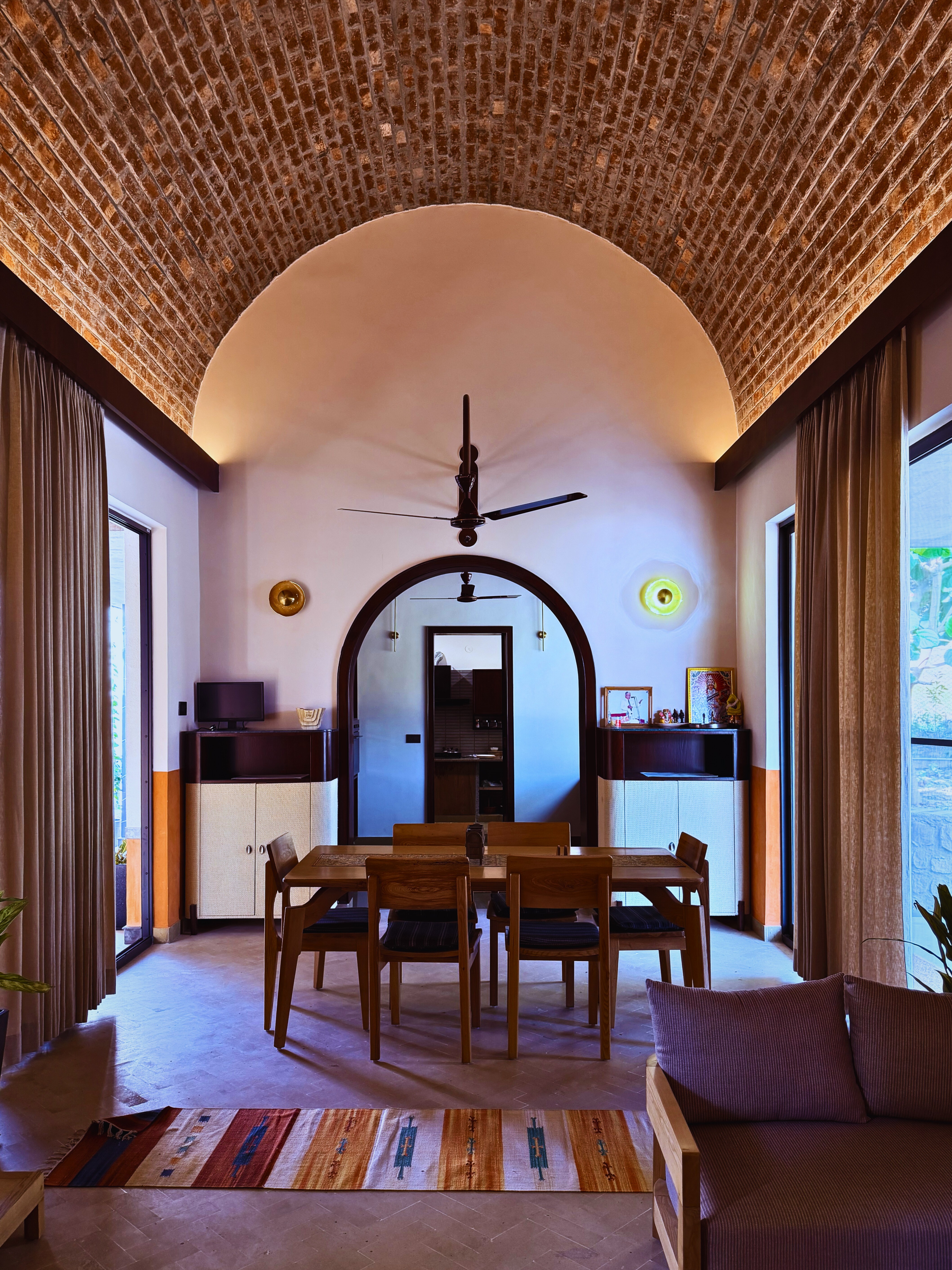 Under the vault: The space is defined by a magnificent exposed brick barrel vault, illuminated by soft cove lighting that celebrates the texture and warmth of the masonry.